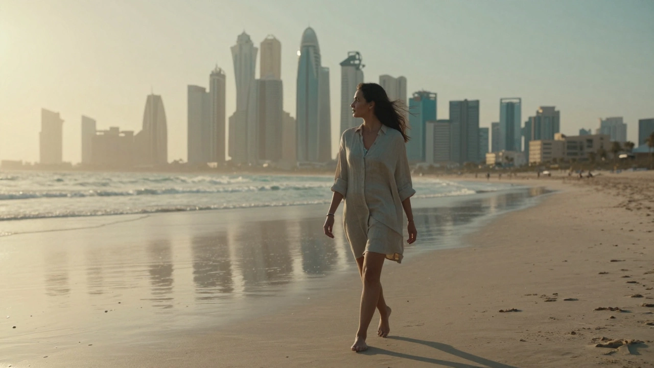 A woman walking barefoot along Jumeirah Beach at sunset, the Dubai skyline glowing behind her.